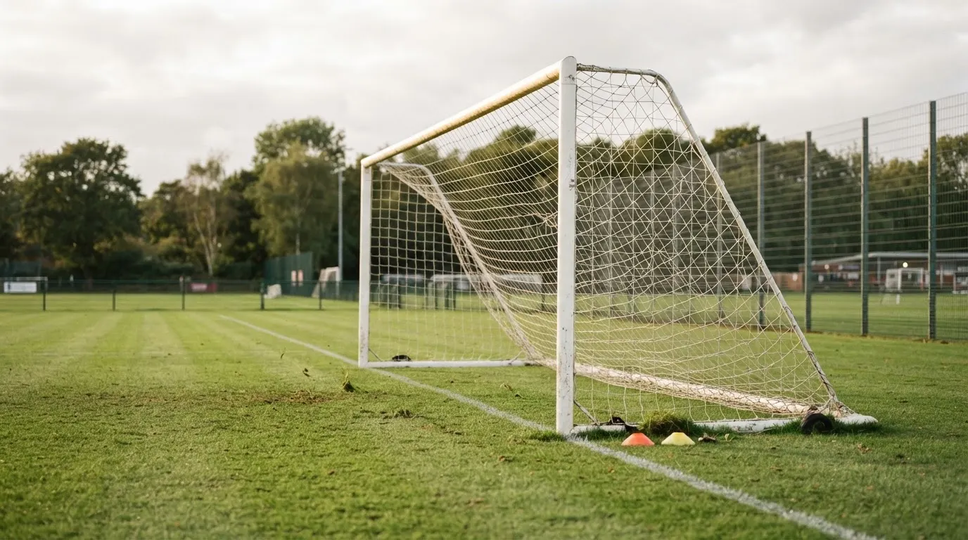 Ein Fussballtor mit locker hängendem Netz auf einem Trainingsplatz, das sich leicht im Wind bewegt.